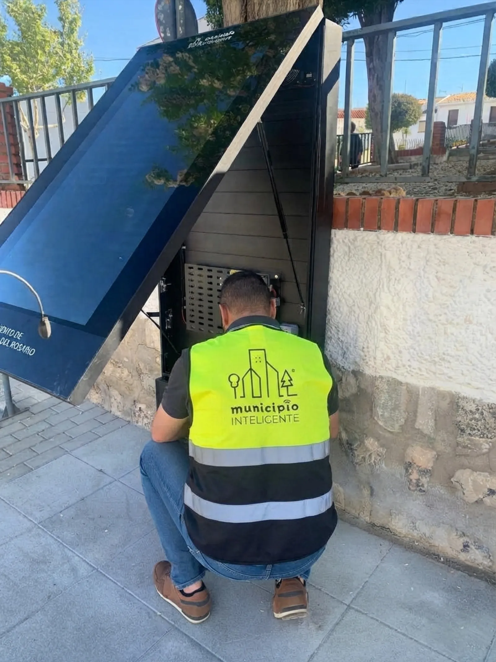 Técnico de Municipio Inteligente revisando el interior de un MUPI en Villanueva del Rosario